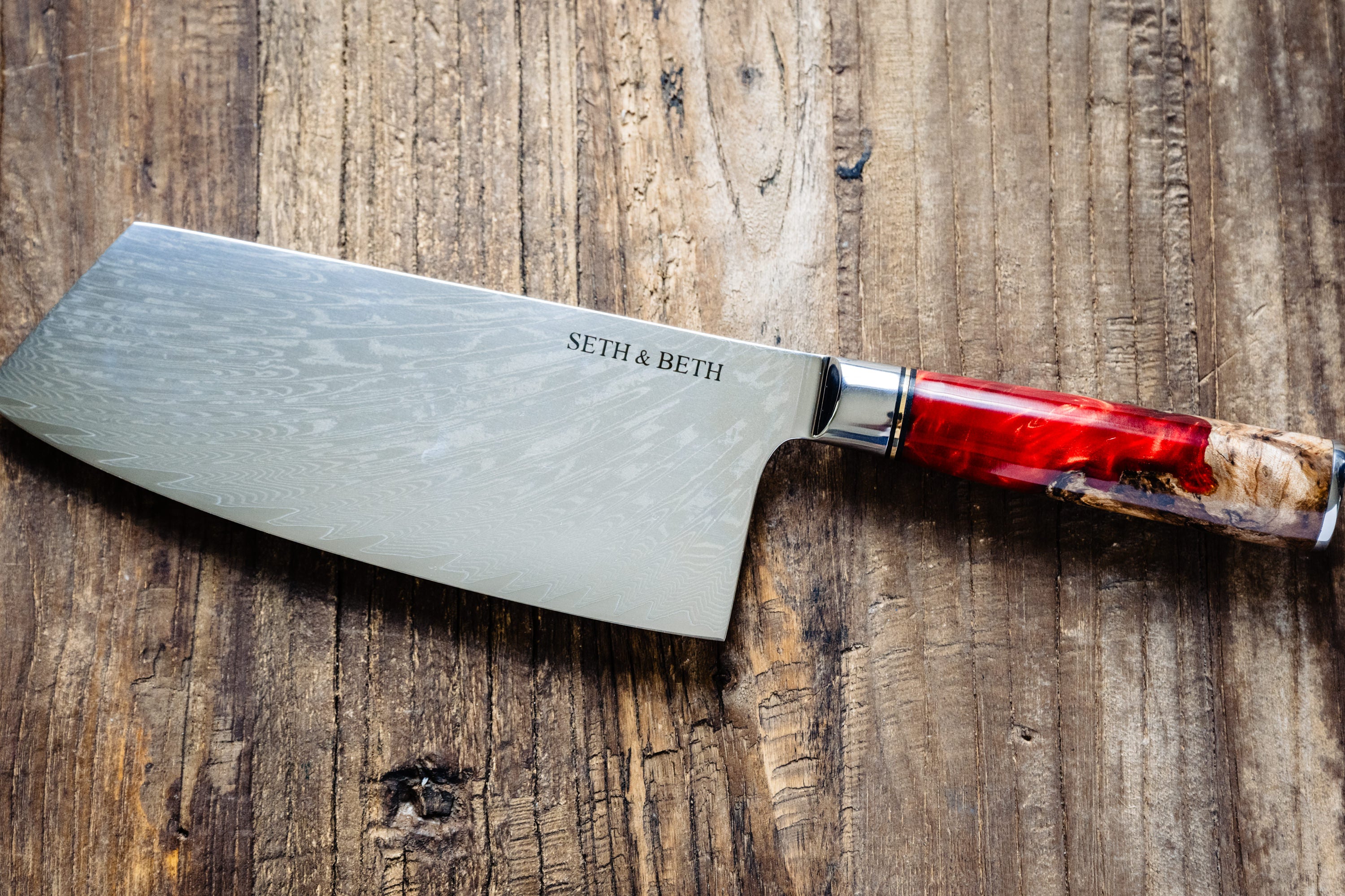 Red burl handle engraved Damascus knife set displayed on wooden surface — Tidal Series